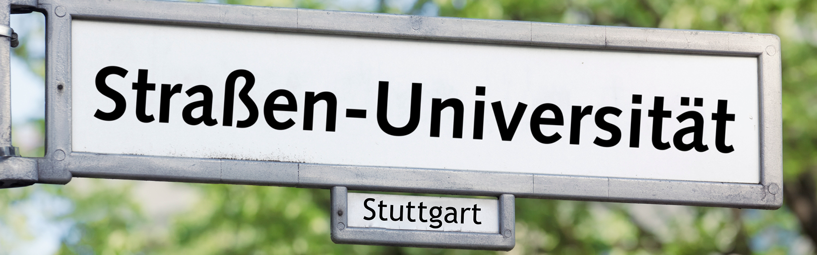 Auf dem Bild ist das Logo des Stuttgarter Straßenuniversität mit dem gleichnamigen Titel auf einem weißen Straßenschild abgebildet.